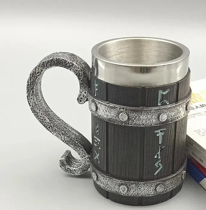 Decorative metal mug with wooden texture and handle on a light gray background
