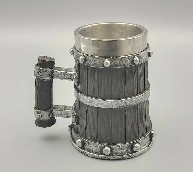 Decorative metal mug with wooden handle on a gray background